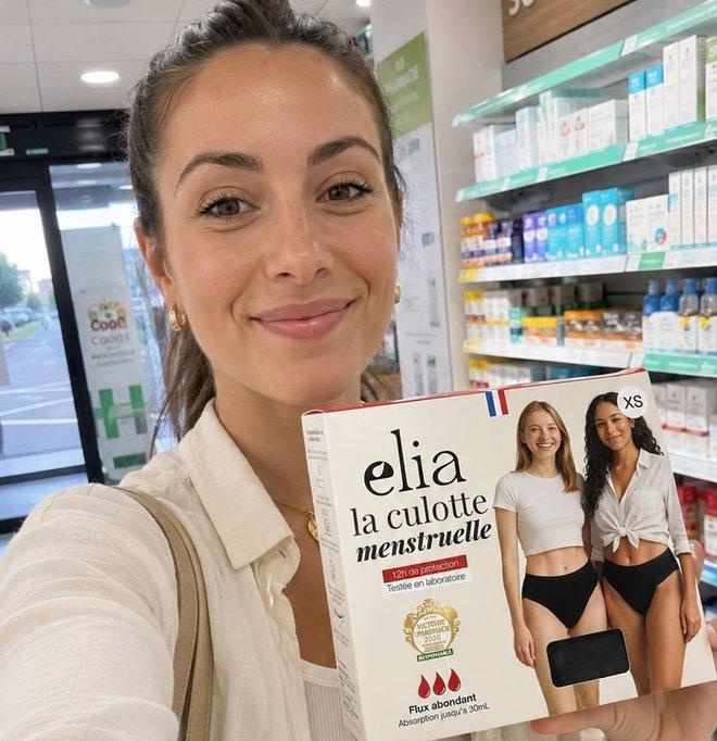 Cliente en pharmacie tenant une boîte de culotte menstruelle Elia flux abondant
